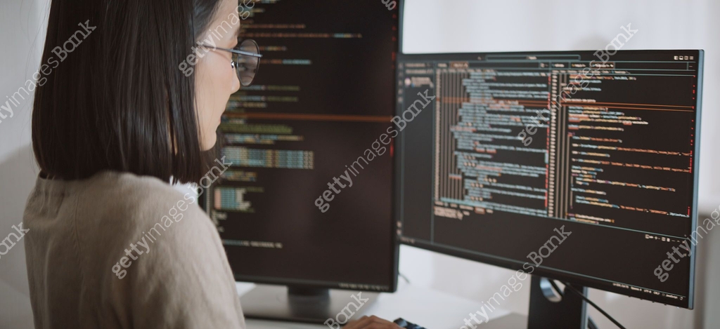 Young adult Asian female software developer coding program on desktop ...