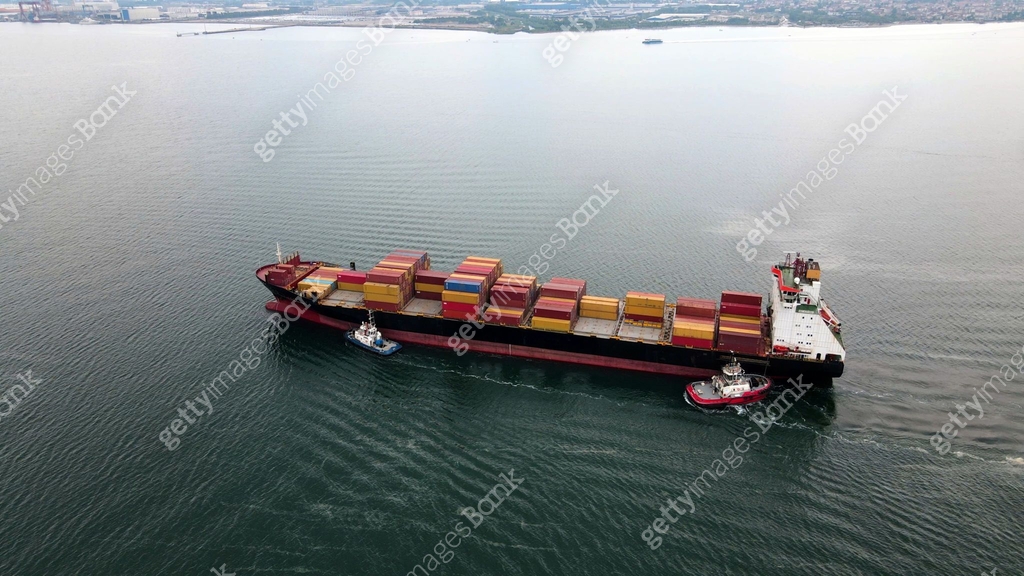 Aerial View of containers ship mooring to dock with pushing from small ...