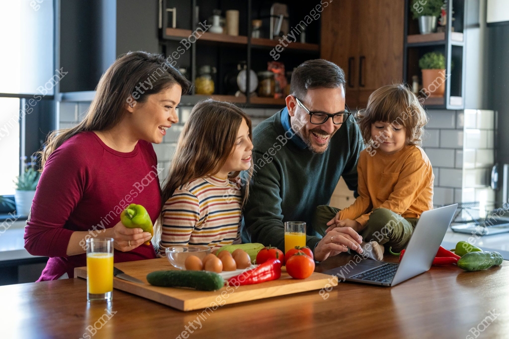 Home Computing Happy Happy young parents with excited small kids using laptop computer at ...
