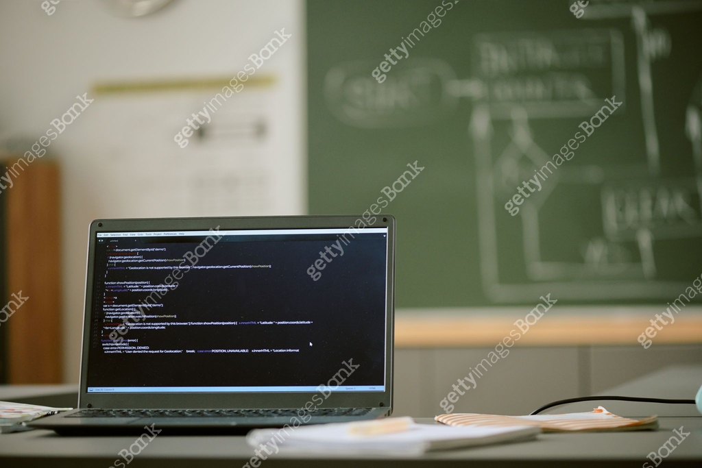 Laptop Displaying Programming Code in Classroom with Chalkboard in ...