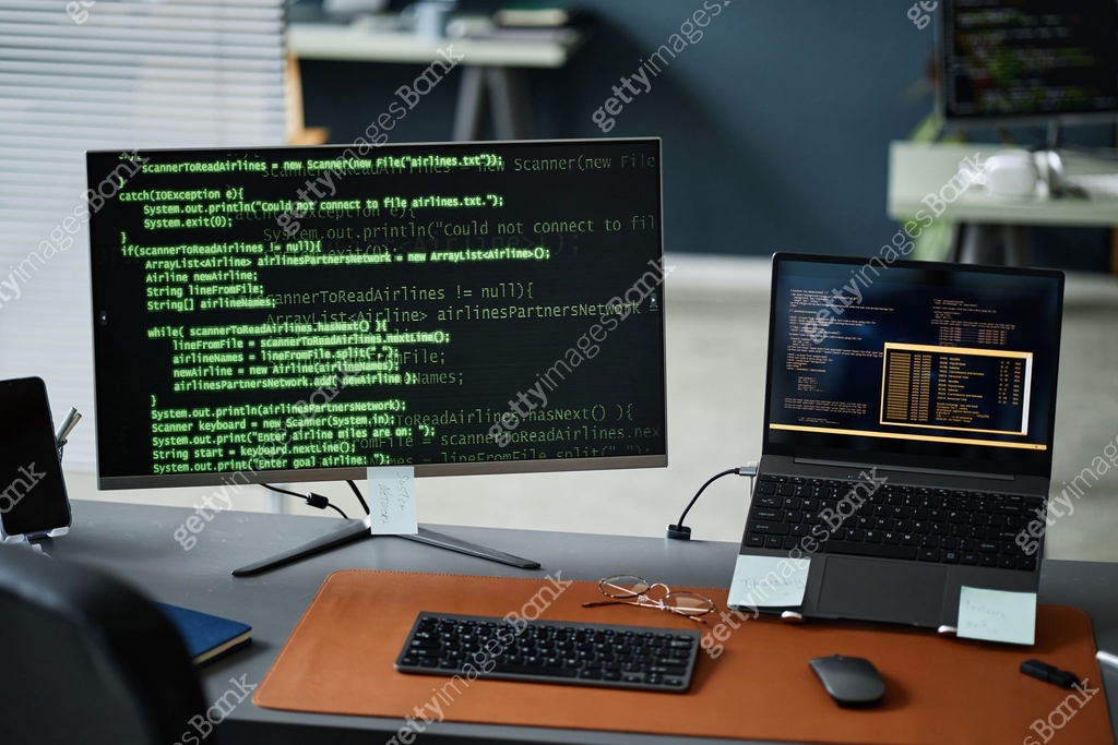 Close up of Computer Monitor and Laptop Displaying Programming Code in ...