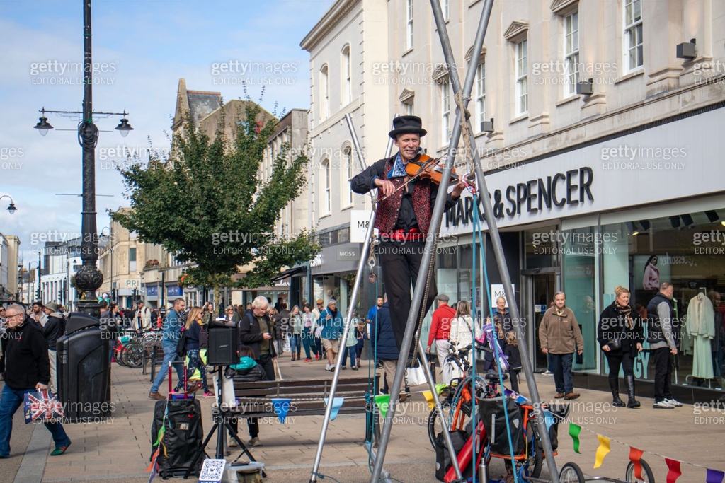 Tight Rope Playing Instruments Talented senior street performer, playing a violin and walking a ...