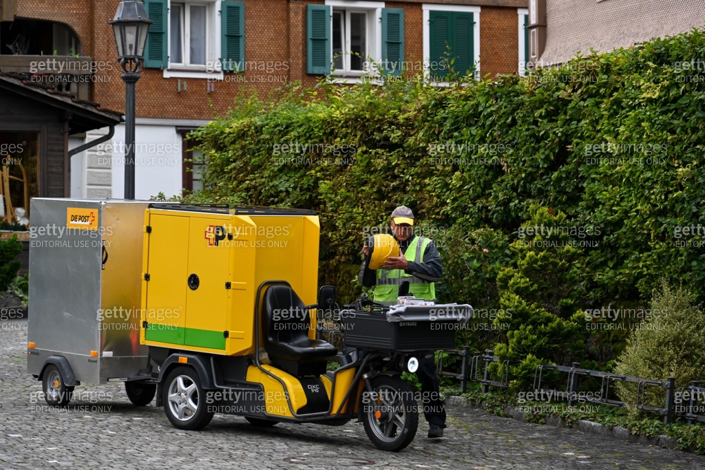 A Swiss Post letter carrier delivering mail in Beckenried on the ...