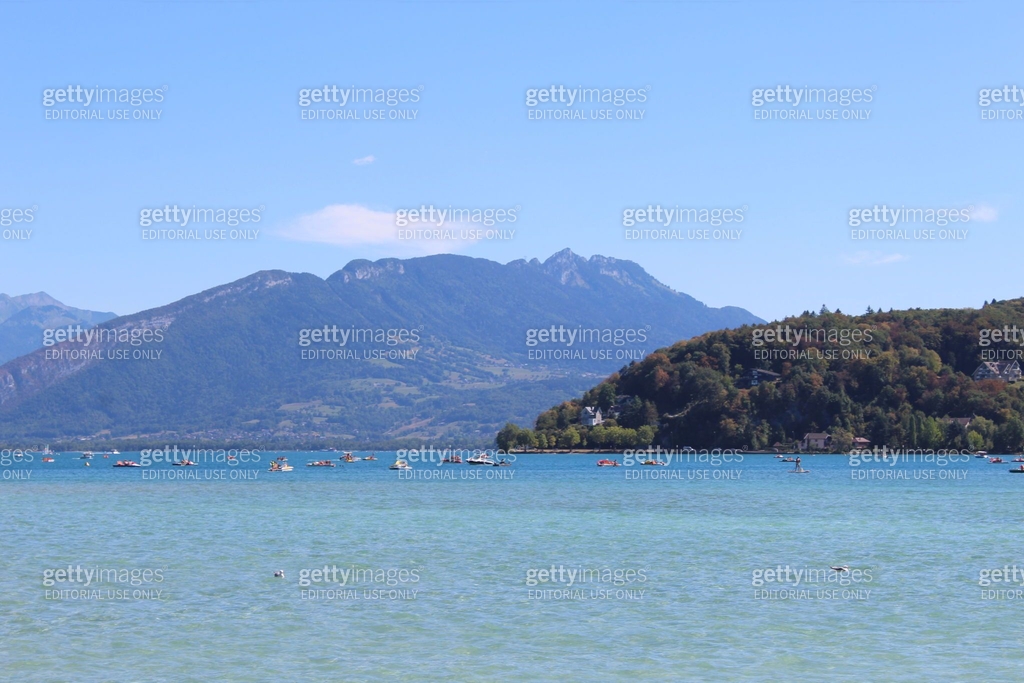 Lake of Annecy city on a backgroung of mountains with blue sky ...