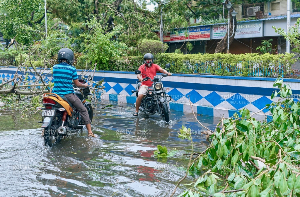 A roadblock in waterlogged Kolkata city street due to uprooted trees ...