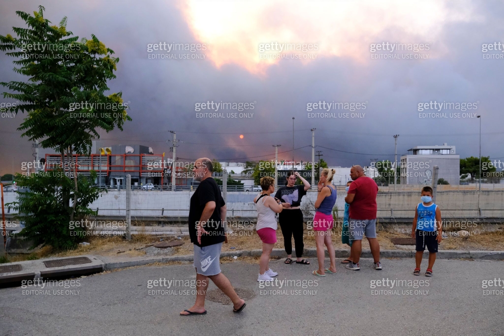 Smoke Rising Greek Residents look at the smoke rising among houses as a wildfire burns in ...