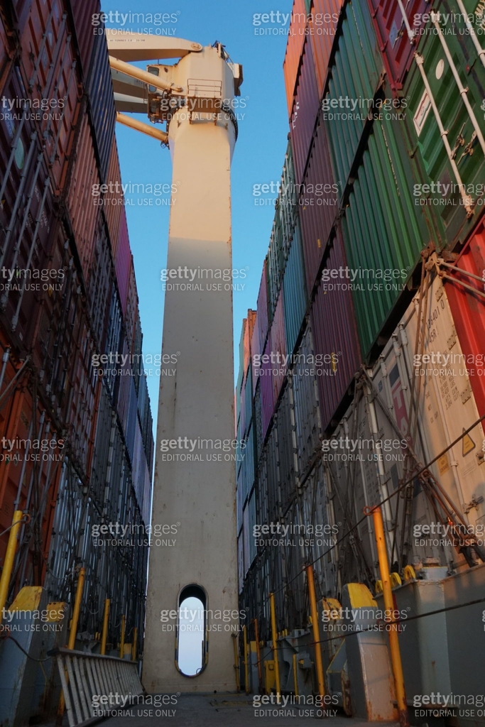 Cream color cargo crane between containers lashed and secured with ...