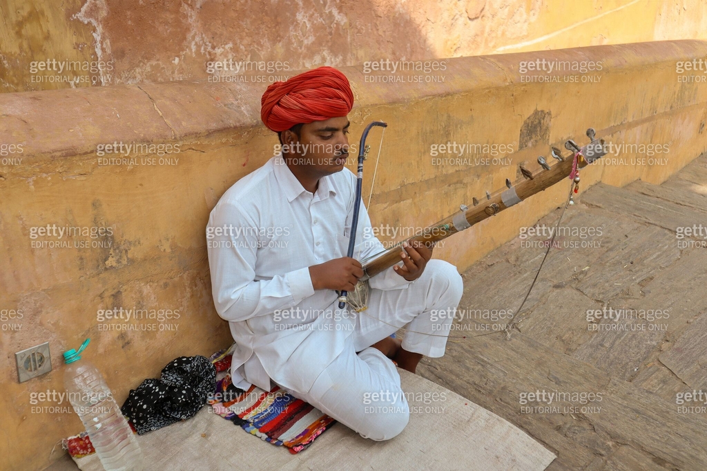 A Young Folk Musician is seen playing the native string instrument ...