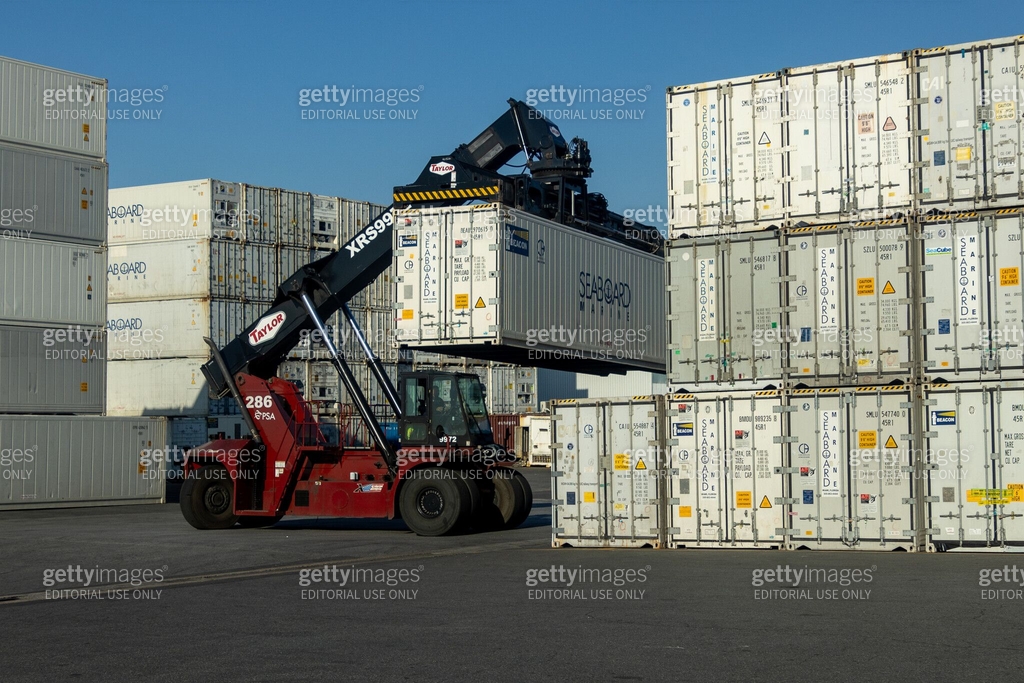 Industrial forklift operating at a container terminal, handling storage ...