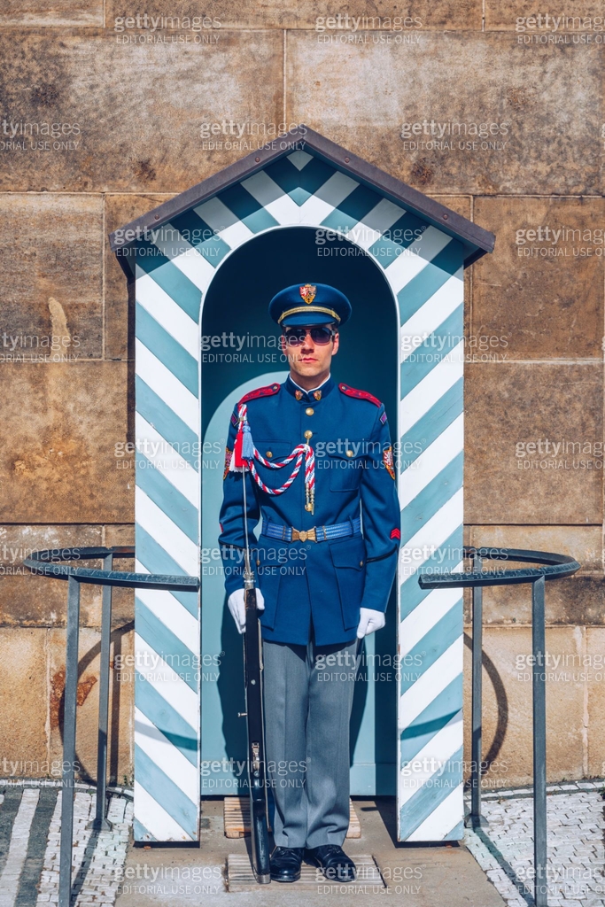 A solitary guard stands at attention in a striped sentry box at Prague ...