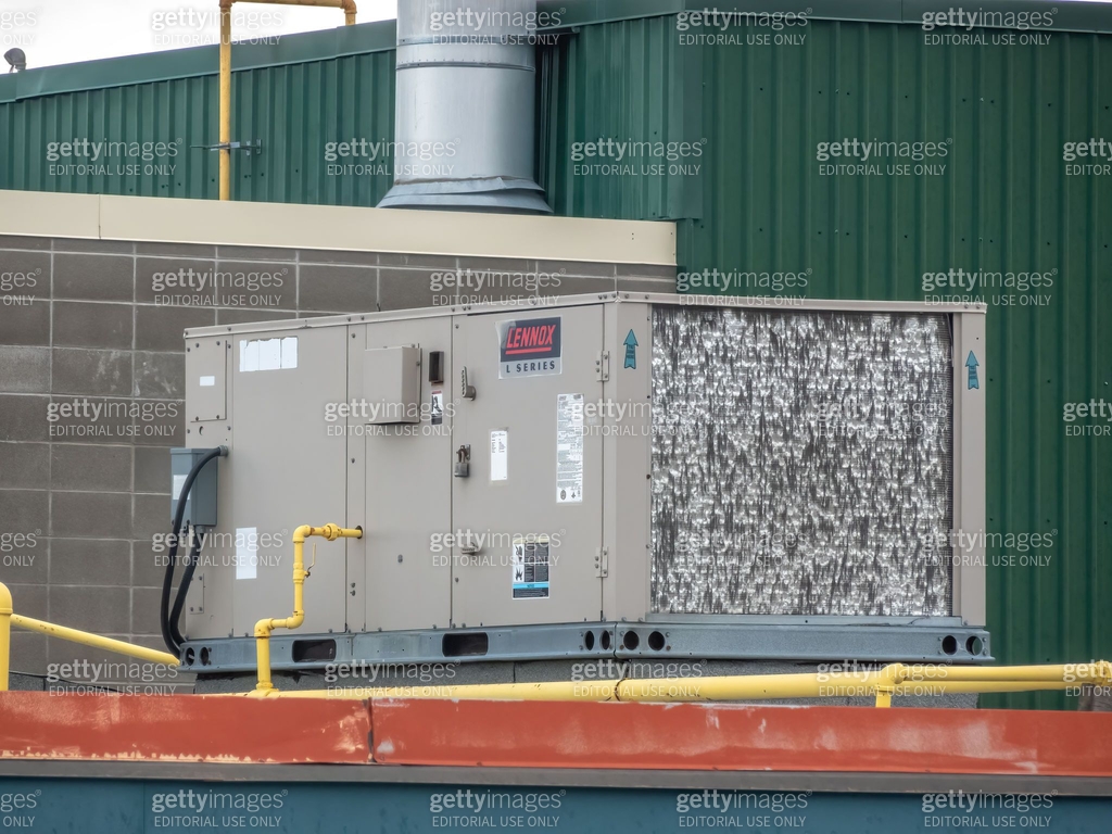 A Lennox commercial rooftop HVAC unit sits atop a building, its metal ...