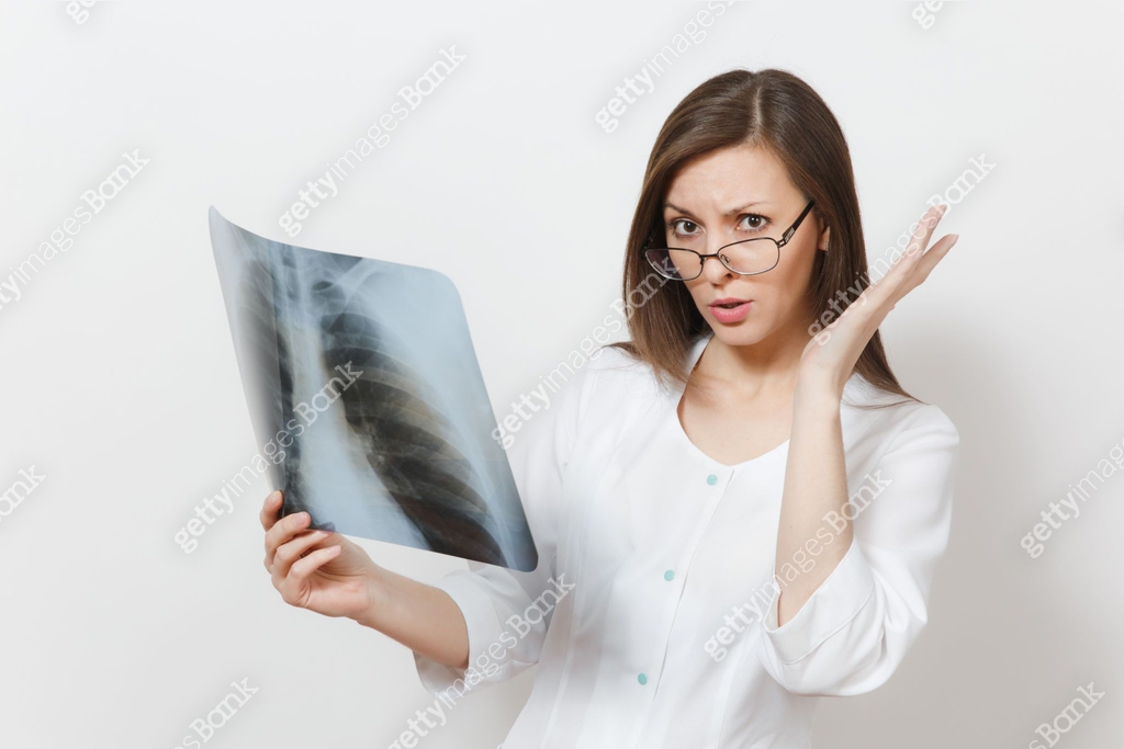 Perplexed focused doctor woman with X-ray of lungs, fluorography ...