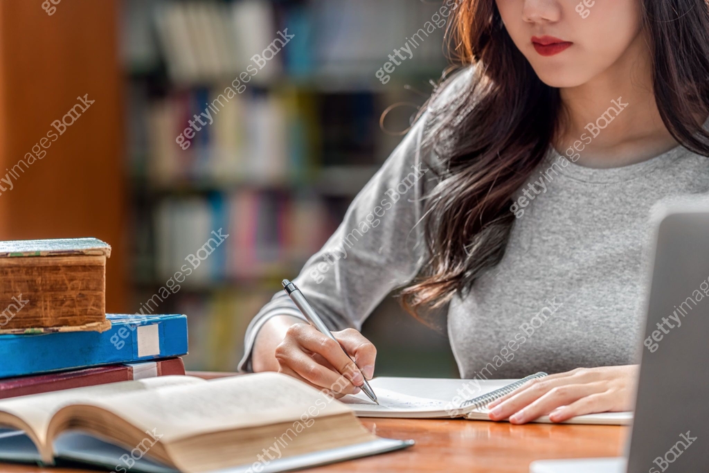 Student Writing Homework Closeup Asian young Student hand writing homework and using technology ...