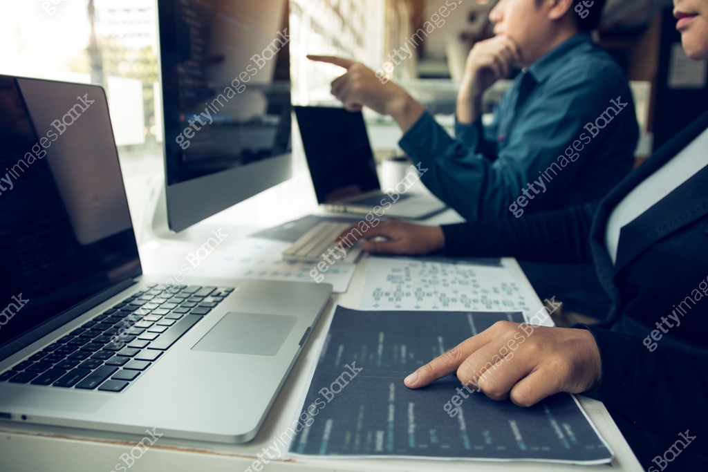 Two software developers are analyzing together about the code written ...