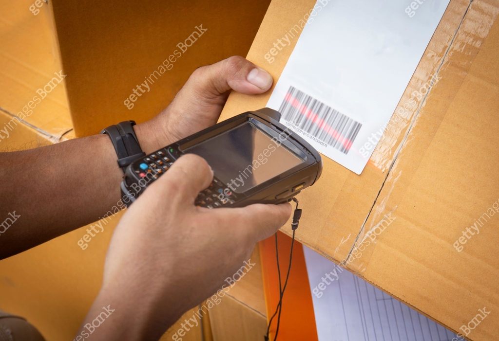 Worker holding barcode scanner scanning red laser on parcel box ...