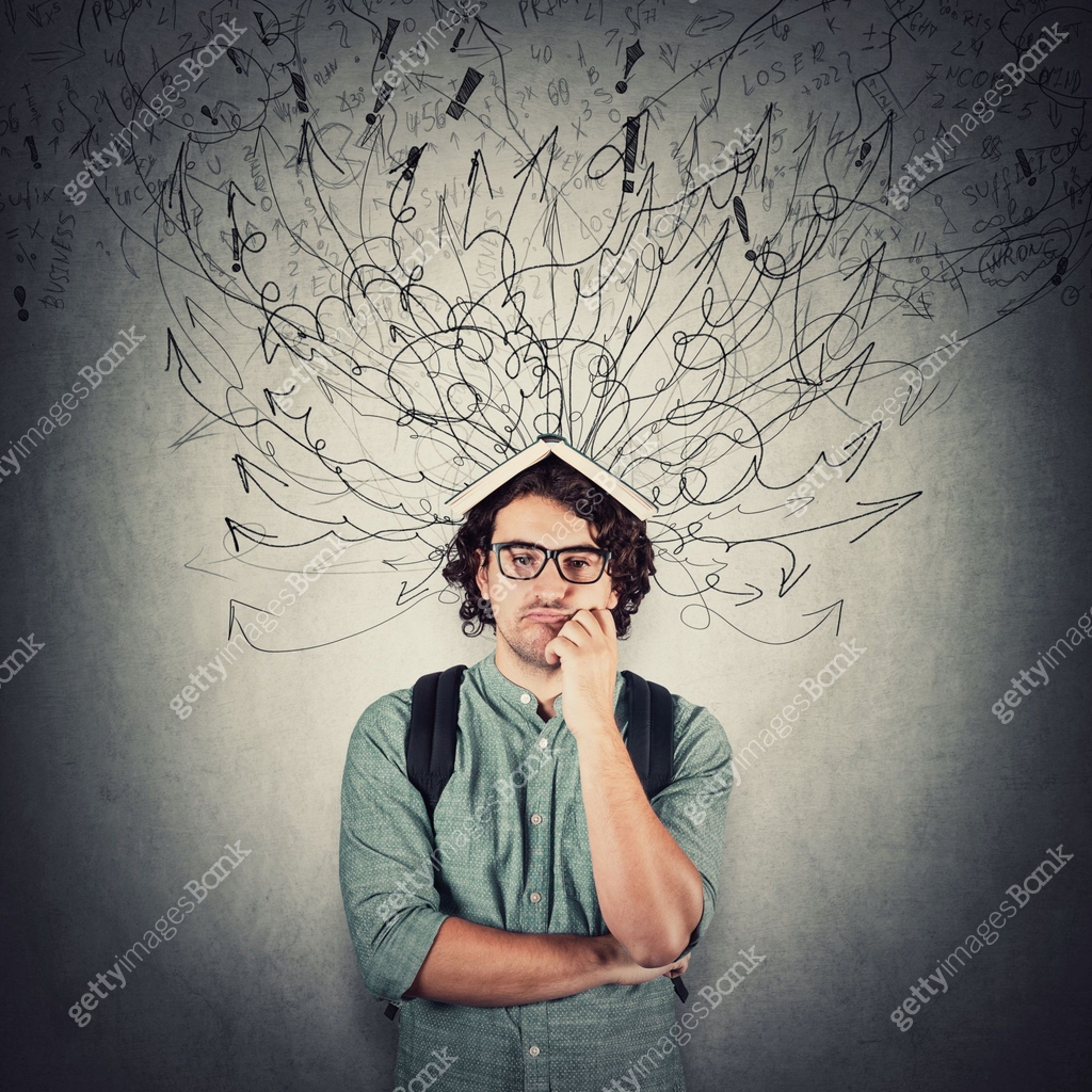 Confused and perplexed student guy keeps hand under cheek, holding a ...