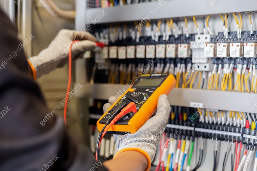 Electrician engineer uses a multimeter to test the electrical ...