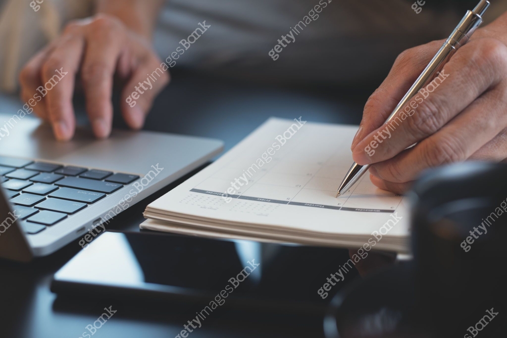 Man hands note on calendar notebook and checking work project planner ...