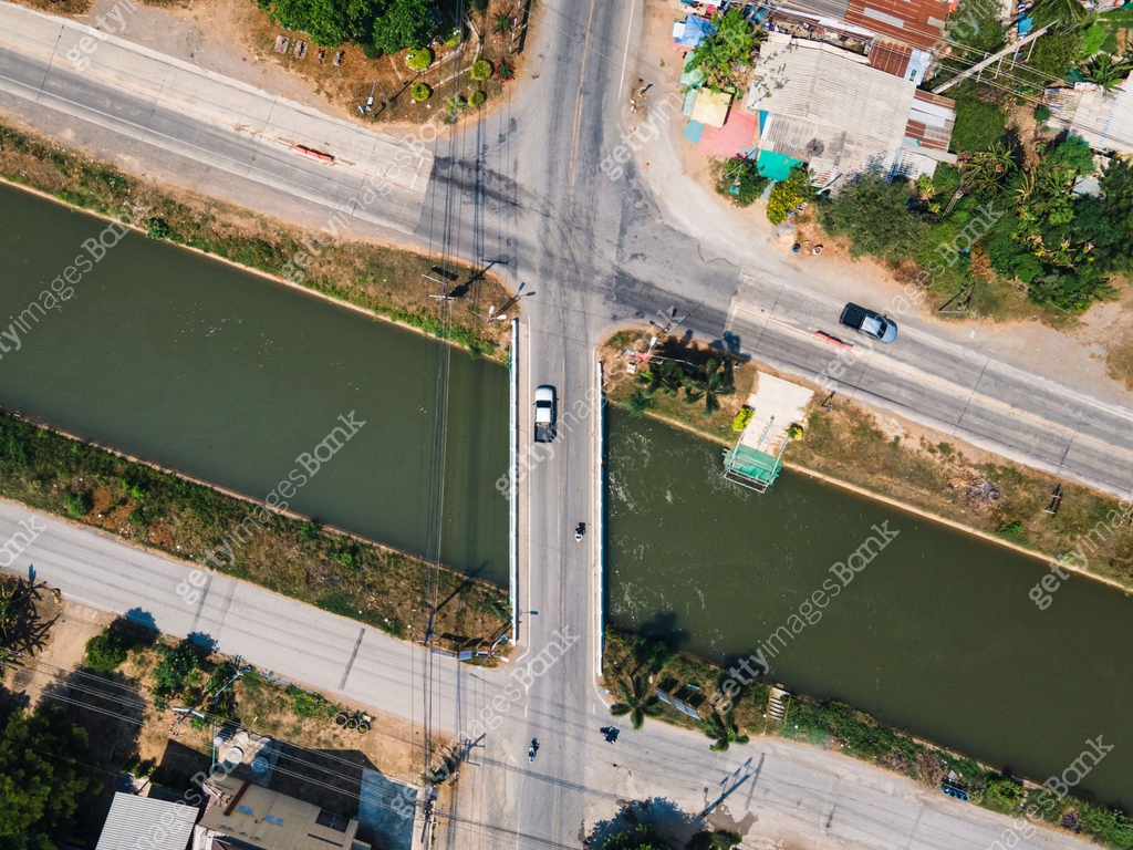 Traffic on intersection road across the bridge on the canal in rural ...