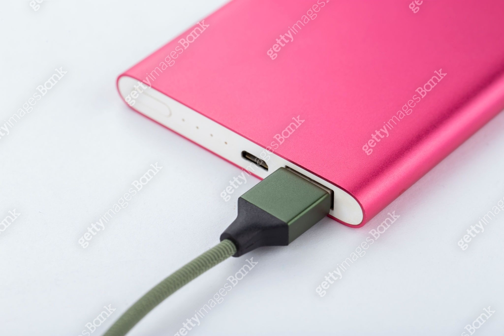 Power bank for charging mobile devices. Pink smart phone charger with ...