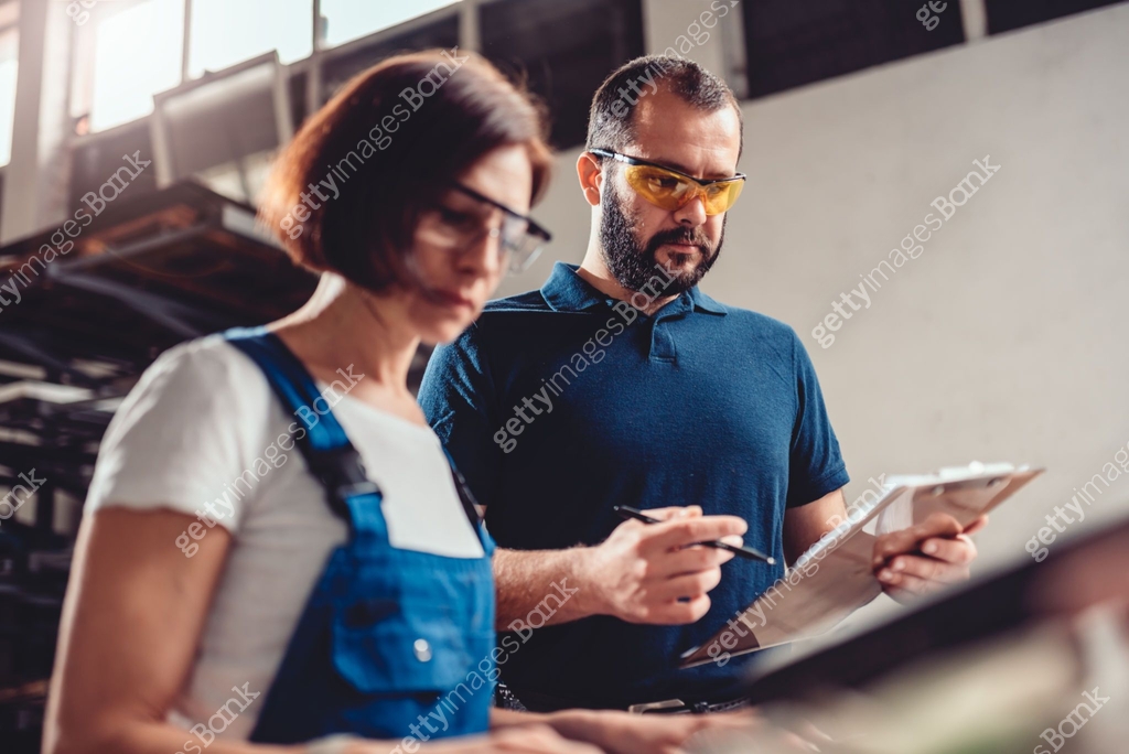 CNC Machine Operator and industrial engineer checking product drawing ...
