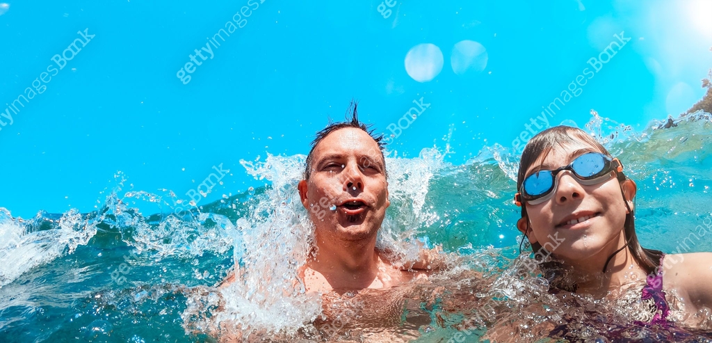 Father and daughter getting splashed by the waves 이미지 (1327530392) - 게티 ...