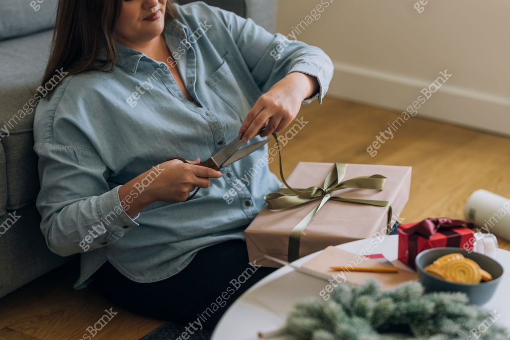 Excessive Wrapping Anonymous Plus Size Woman Cutting the Excess Ribbon while Wrapping ...