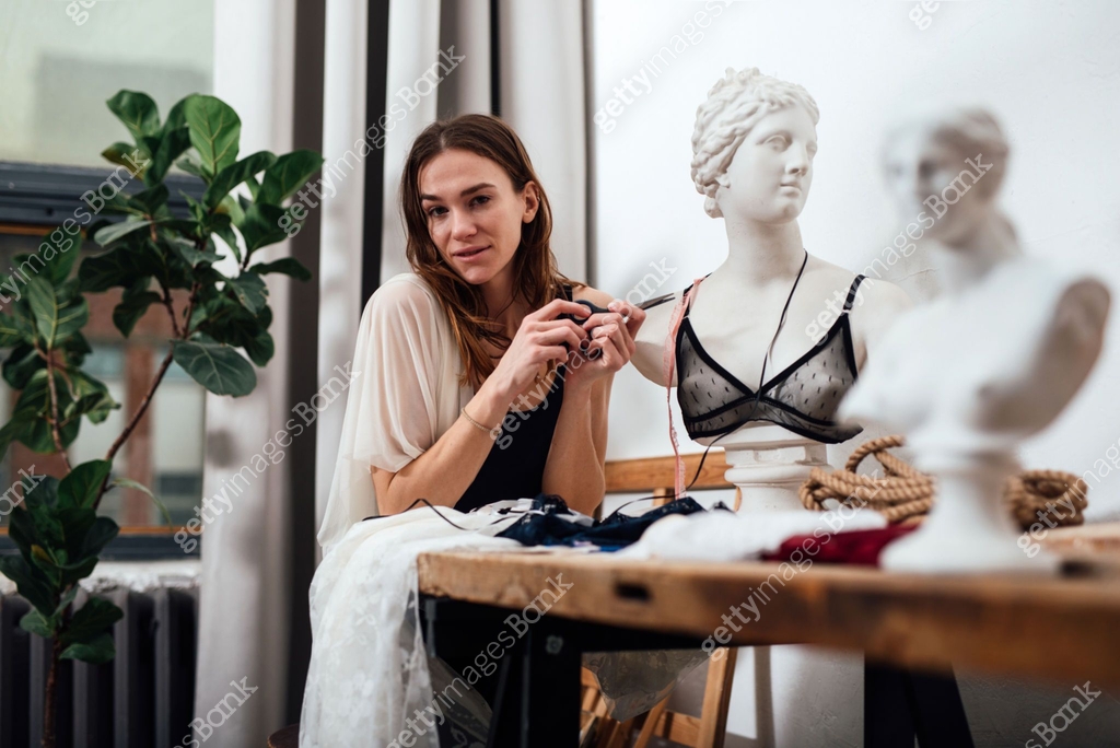 Female lingerie designer sits in her workshop 이미지 (1325785822) - 게티이미지뱅크
