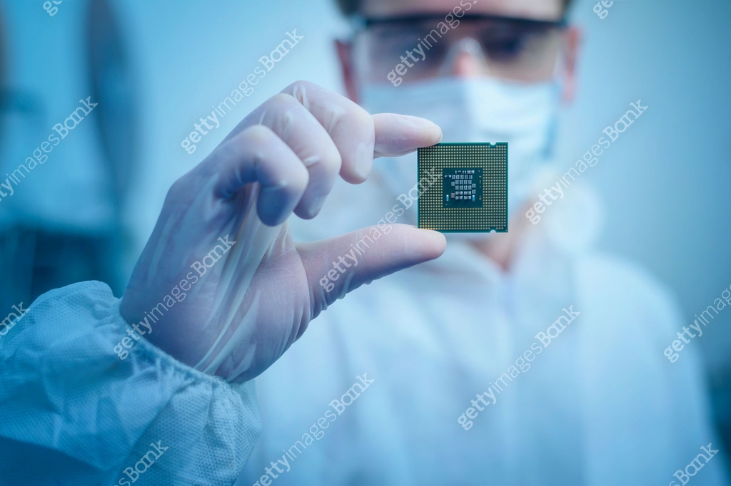 Engineer man in sterile suit is holding Microchip with symbols in ...