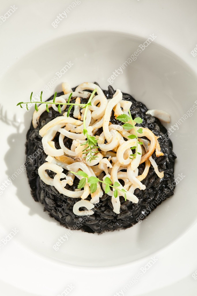 Risotto with cuttlefish black ink. Black risotto plate isolated on ...