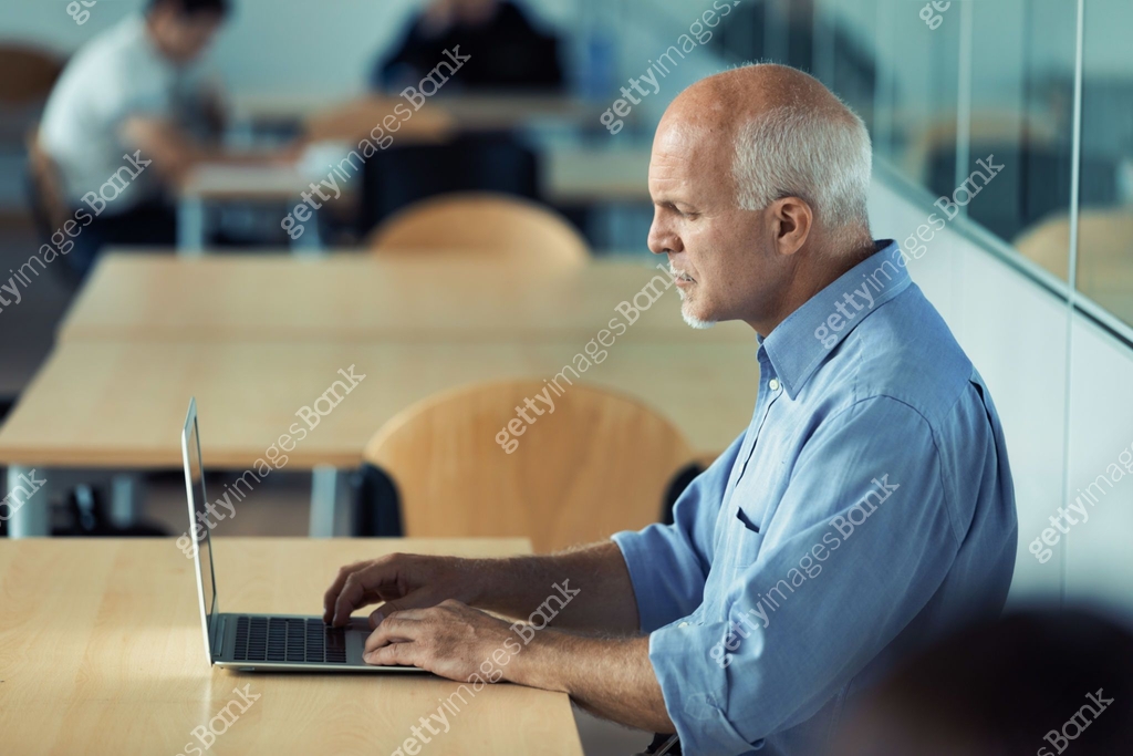 Profile view of a senior businessman working on laptop computer 이미지 ...