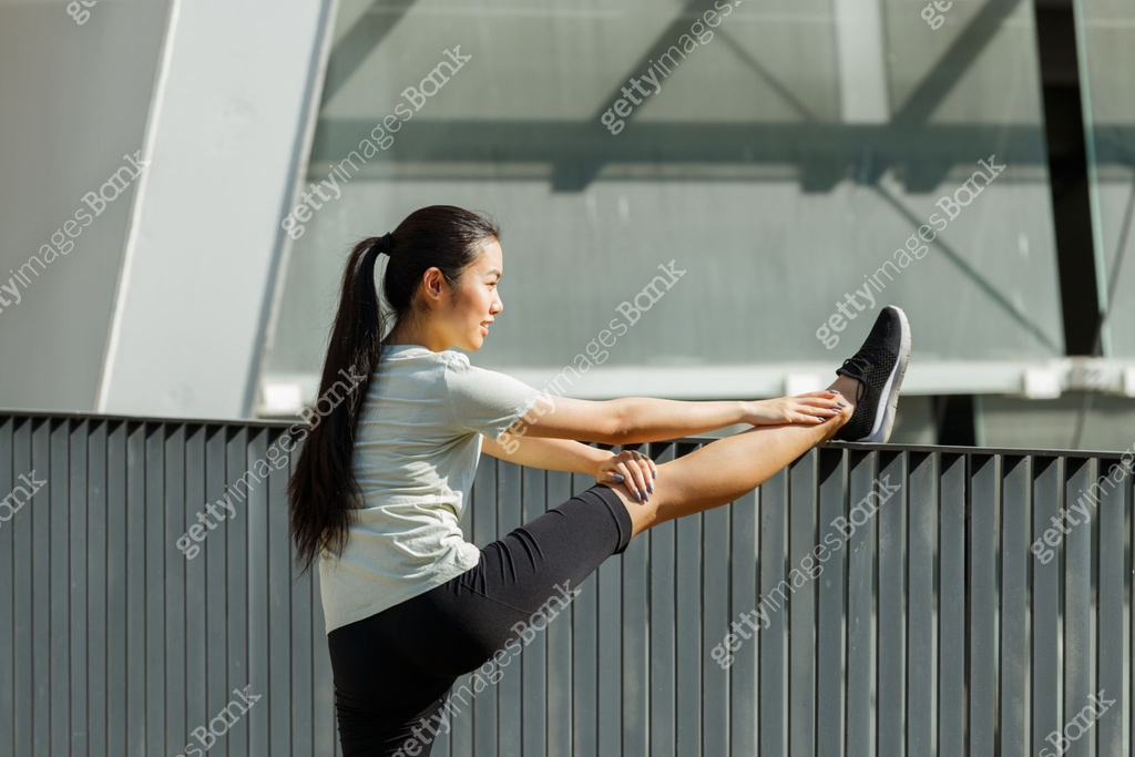 Asian woman does leg stretching exercise leaning on railing 이미지 ...