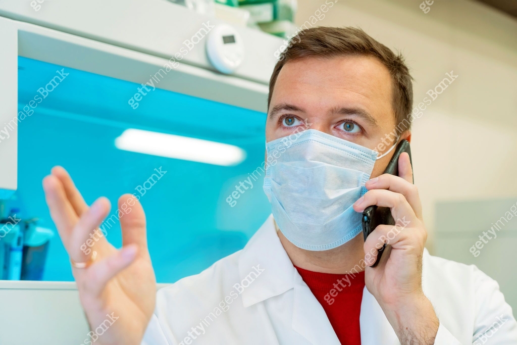 Male scientist in medical mask talking on smartphone in biochemistry ...
