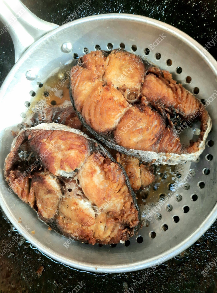 Fried King Mackerel fish in colander - food preparation. 이미지 ...