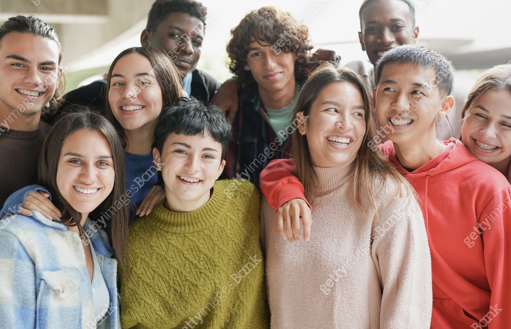 Diverse young students hugging each other outdoor of school building ...
