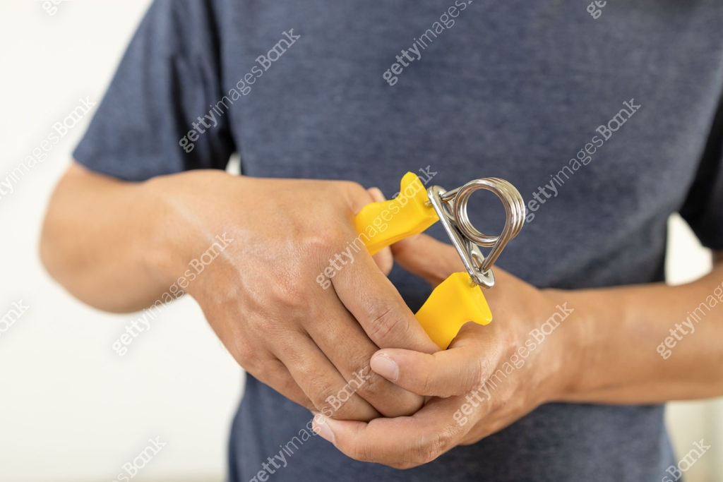 Hands of male patient is doing palm or wrist exercise with spring hand ...