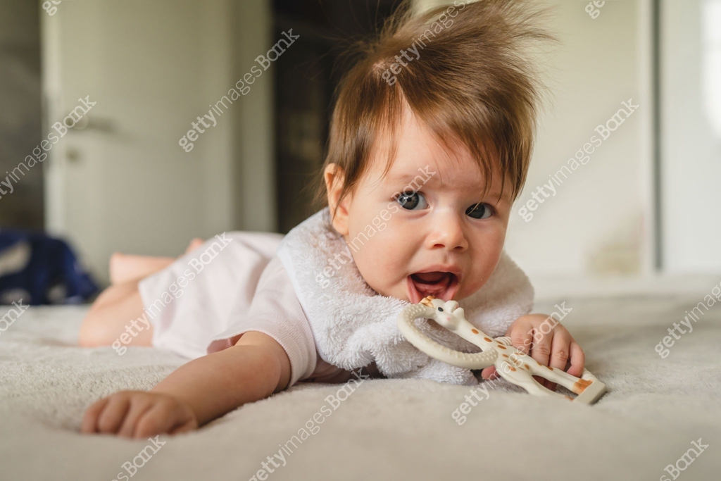 Small caucasian baby four or five months old having teeth growing Small caucasian baby four or five months old having teeth growing