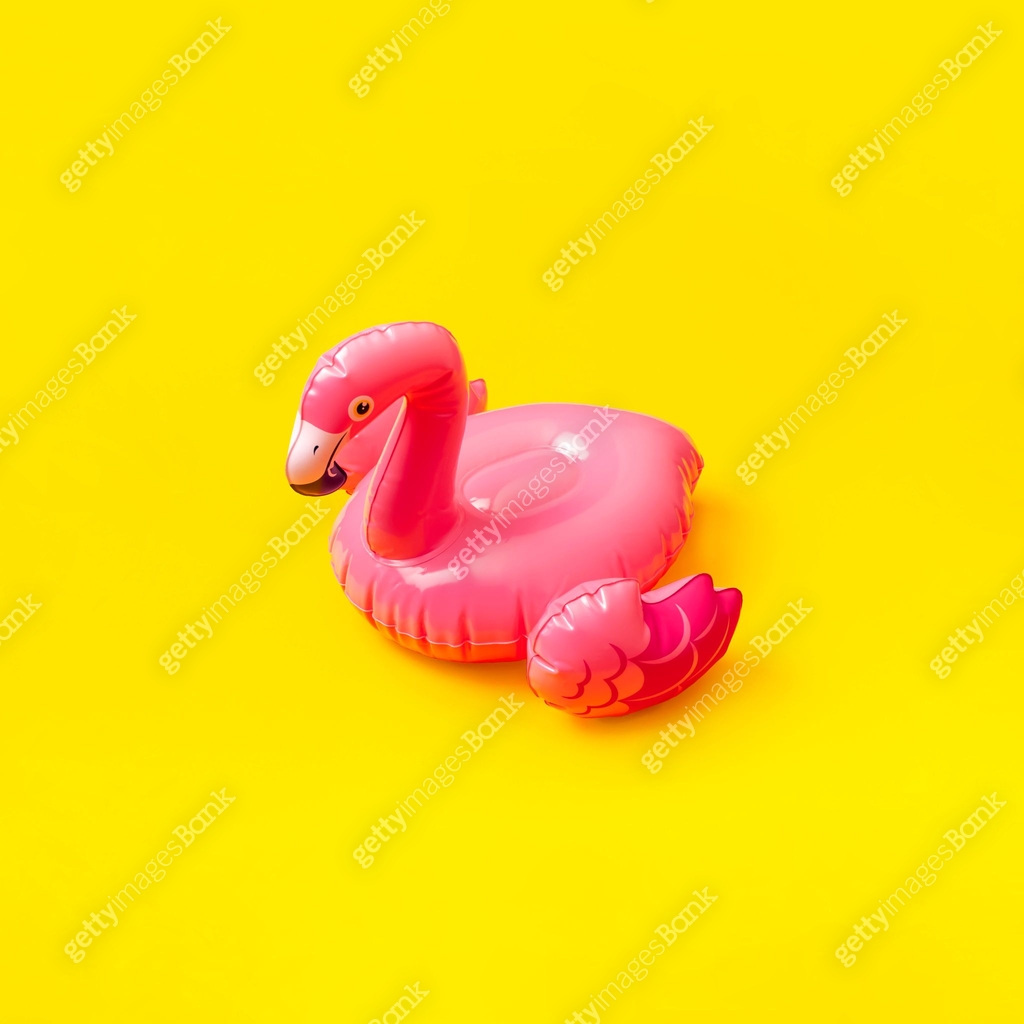 Creative summer beach concept. Inflatable pink mini flamingo on yellow ...