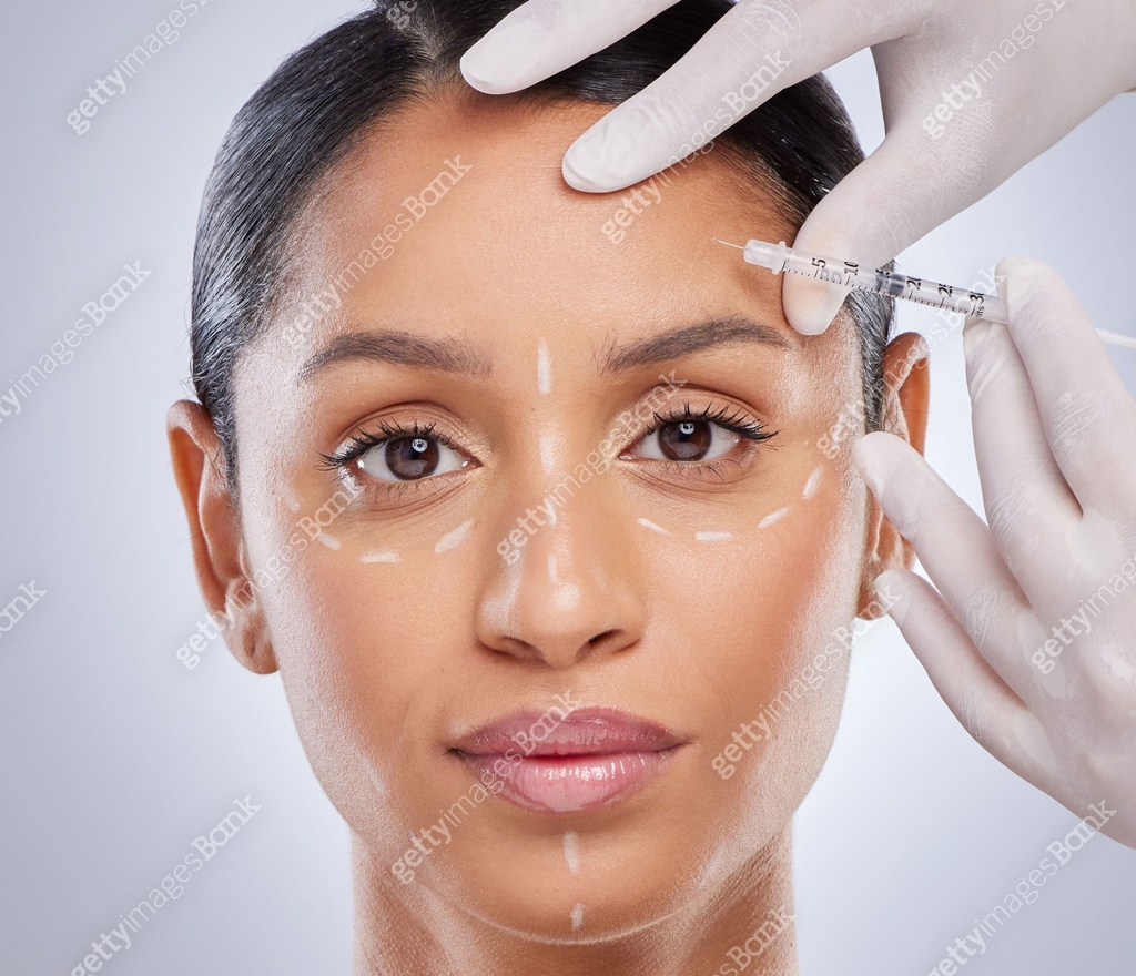 Shot of an attractive young woman getting filler injections in the ...