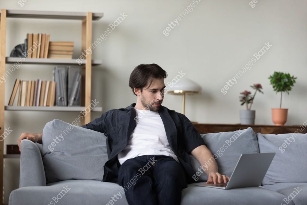 Relaxed Computer User Relaxed millennial laptop user guy resting on couch, watching movie 이미지 ...