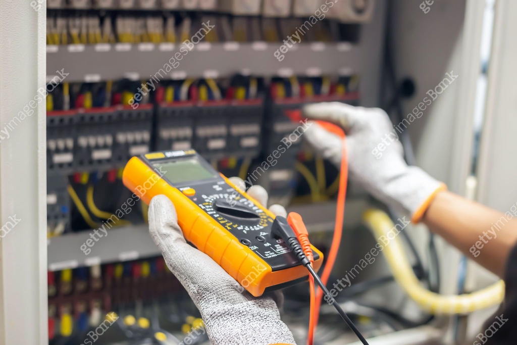 Electrical Function Test Electrician engineer uses a multimeter to test the electrical ...