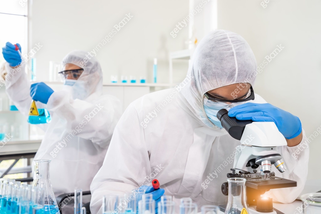 Researcher in laboratory personal protective equipment suit or PPE ...