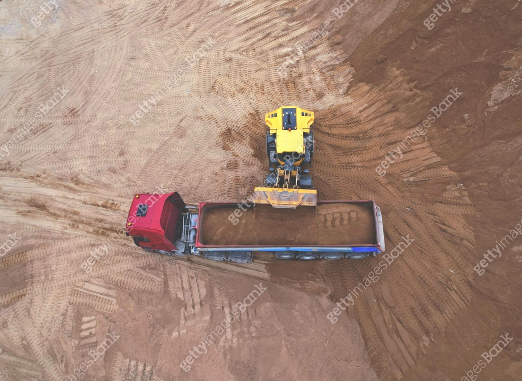 Wheel loader load sand in tipper truck in open pit. Front end loader on ...