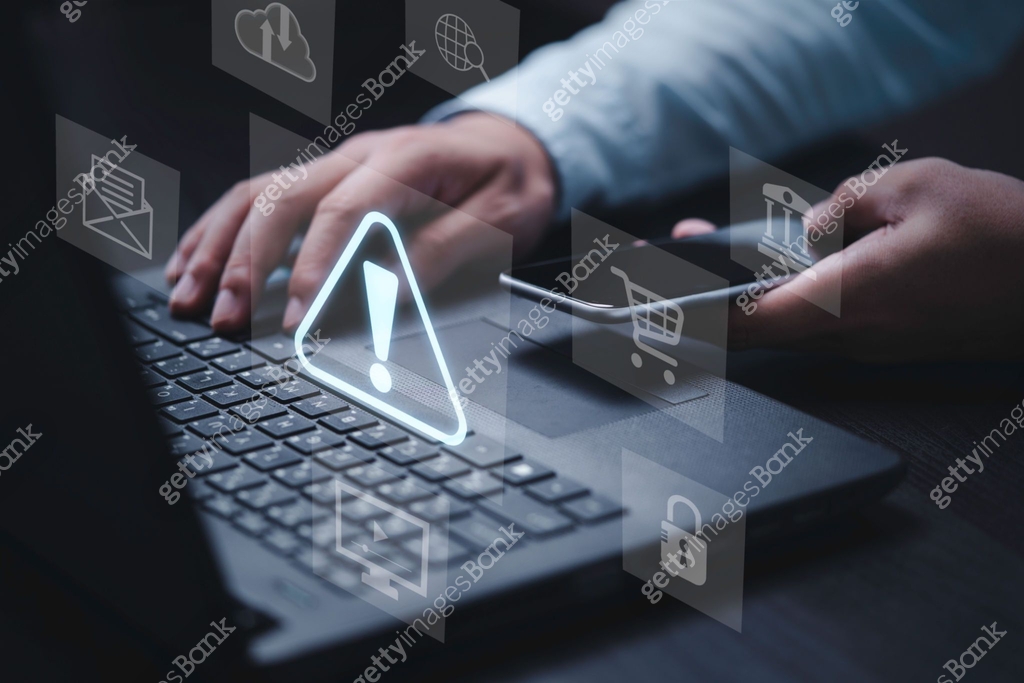 Businessman using computer laptop with triangle caution warning sing ...