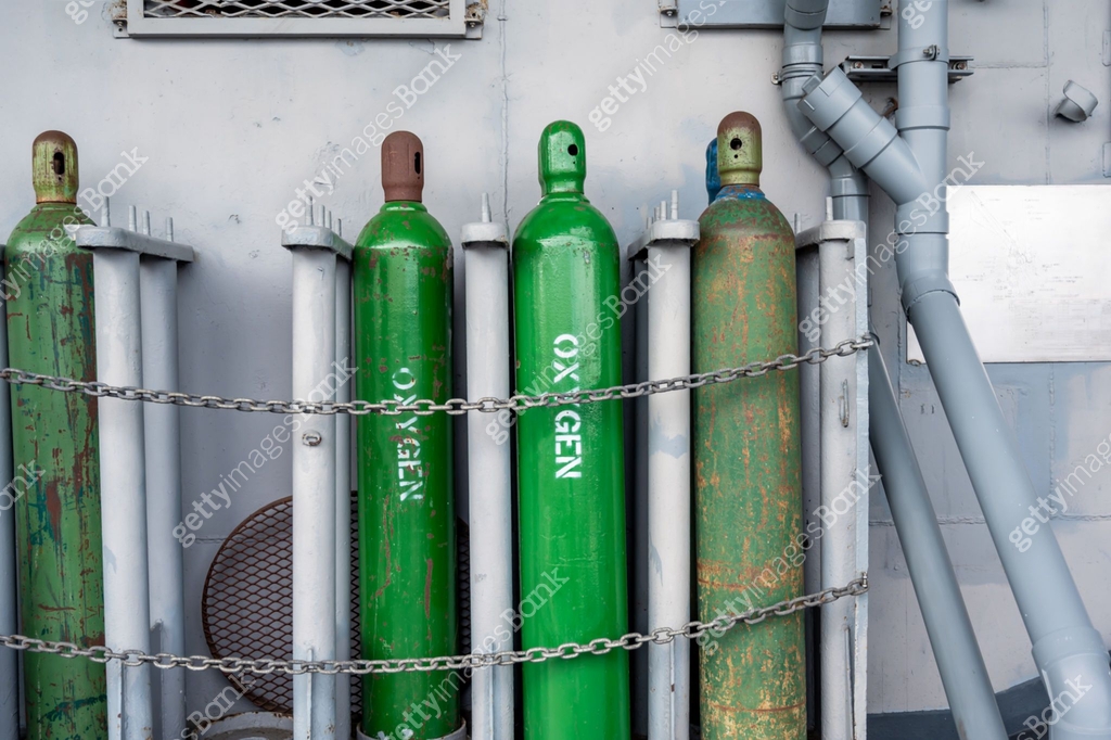Compressed gas cylinders being stored vertically secured by a metal ...