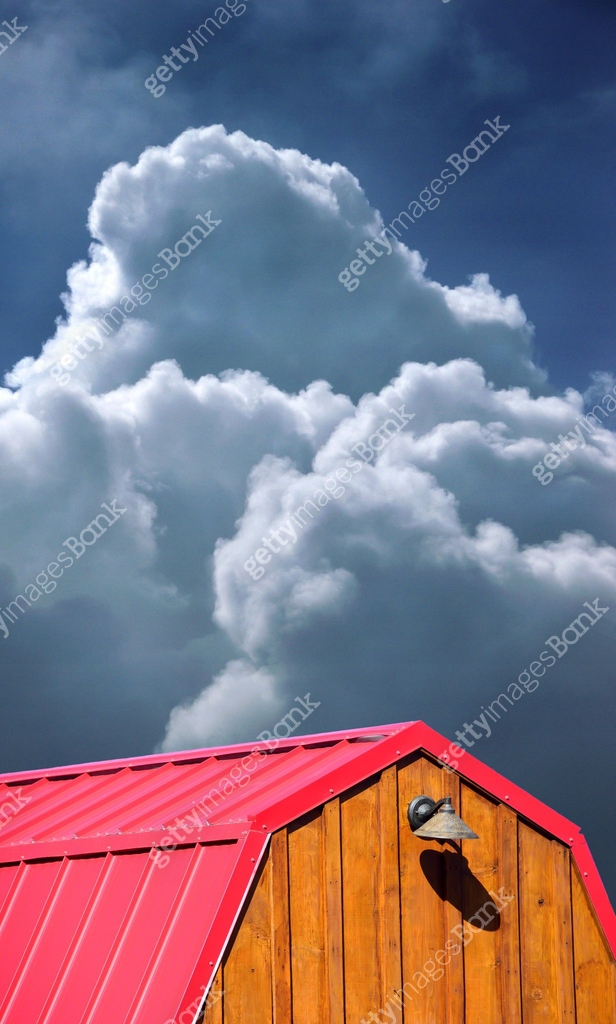 Bright red storage shed standing out against gathering heavy and ...