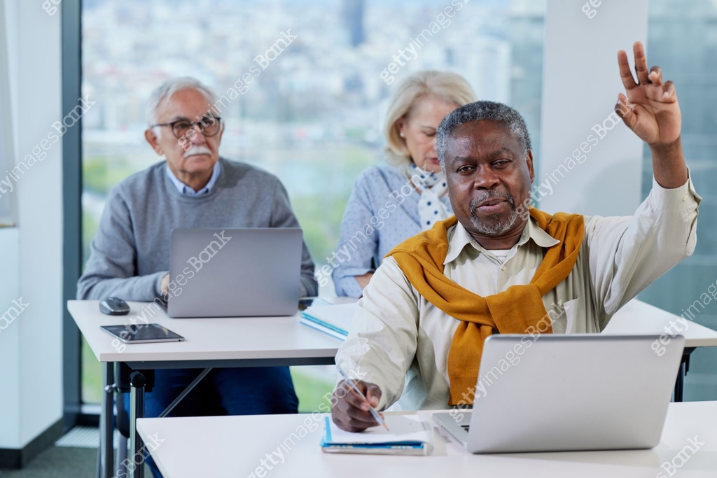 Retraining Class A senior man is working on a laptop while having a retraining class ...