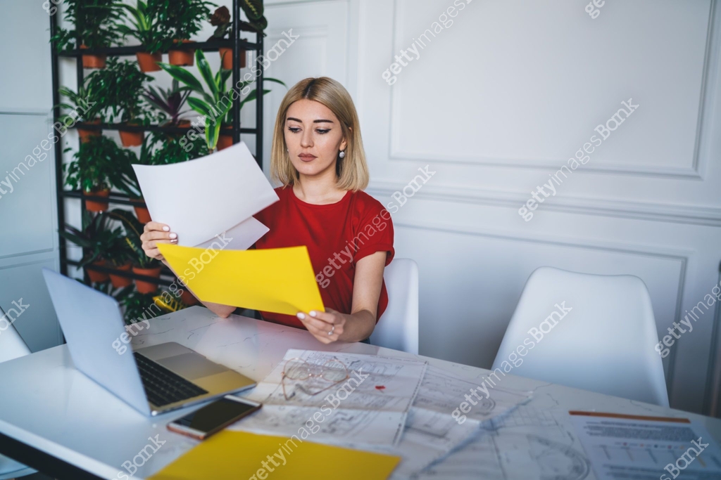 Stylish woman comparing papers in office 이미지 (1432545881) - 게티이미지뱅크