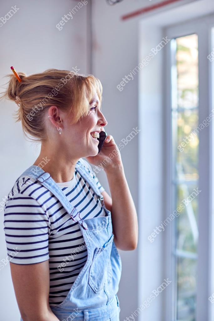 Woman Decorating Room In House Making Phone Call Using Mobile Phone 이미지 ...