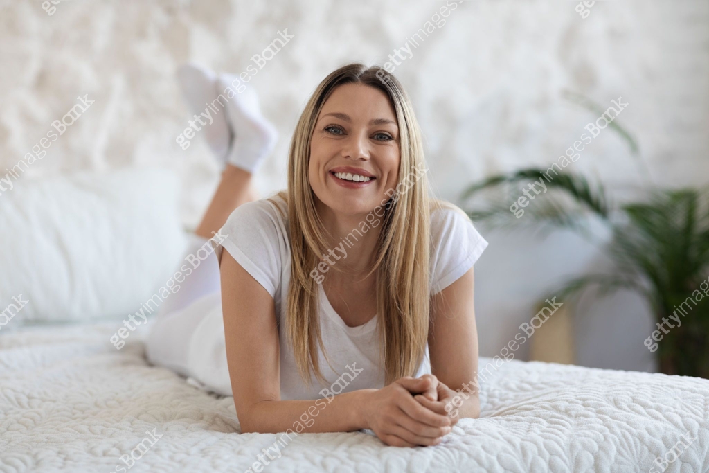 Well-rested blonde woman enjoying happy morning, posing in bed 이미지 ...